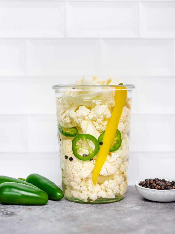 Scharf fermentierter Blumenkohl mit Karotten, Habanero-Chili und Pfefferkörnern in einem Einmachglas – bunt, hausgemacht und würzig