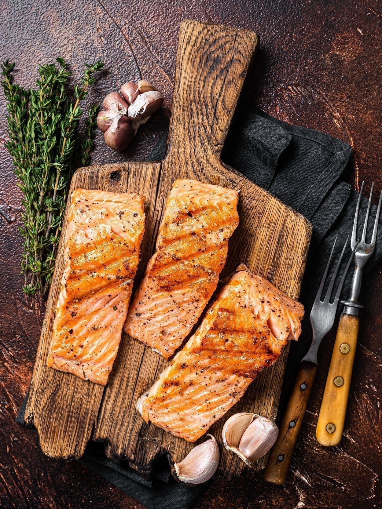 Saftig gegrillte Lachsfilets auf rustikalem Holzbrett
