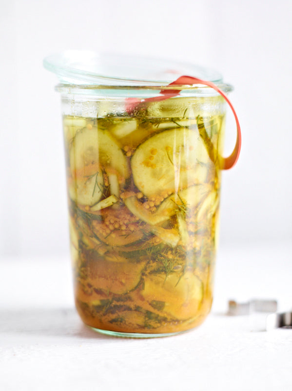 Hausgemachte Gurkenpickles mit Dill, Zwiebeln und Senfkörnern in einem hohen Weckglas – süß-sauer eingelegt und aromatisch gewürzt