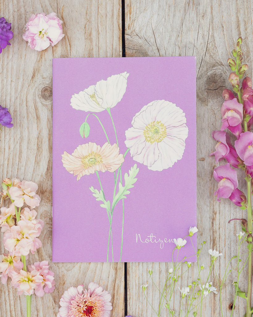 A5 Notizheft Islandmohn – Gartenzauber Papeterie auf Holztisch, umgeben von Sommerblumen.