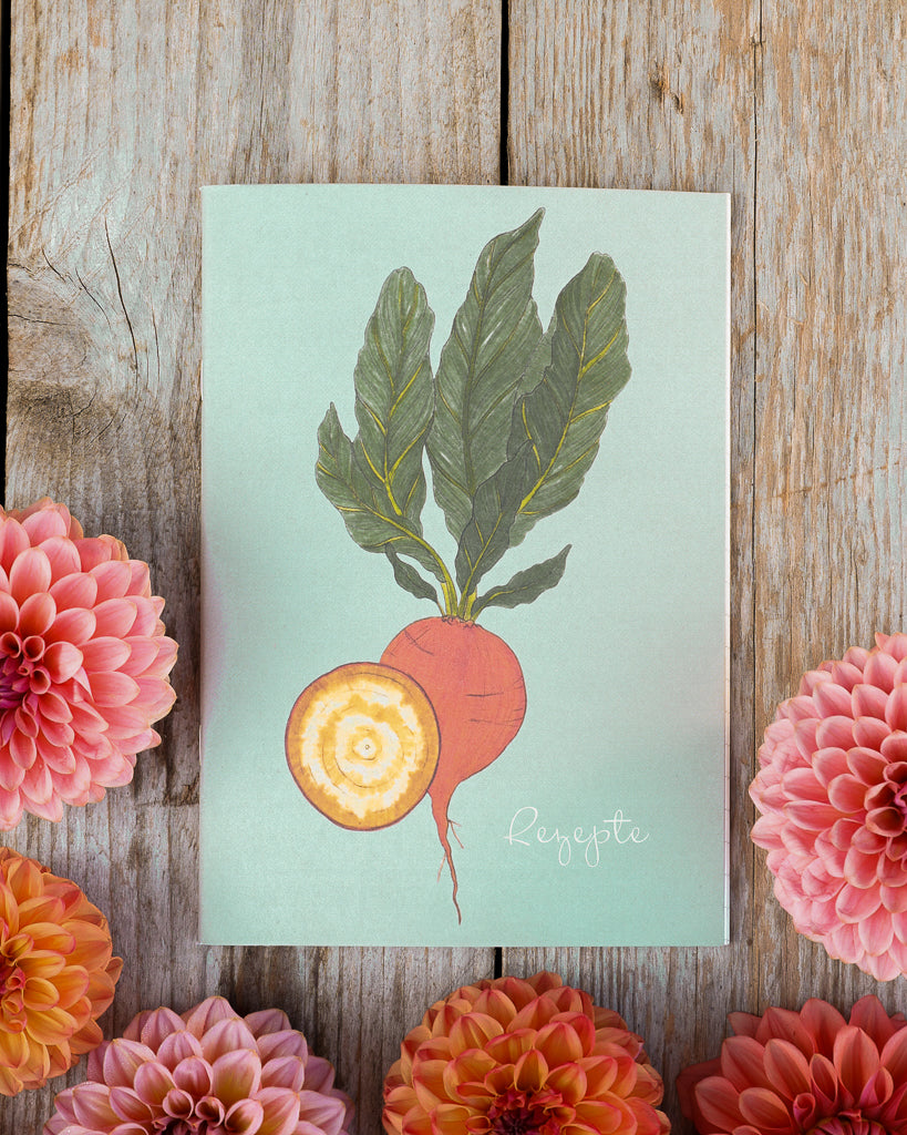 A5 Notizheft Rote Bete Wintersonne – Gartenzauber Papeterie auf Holztisch, umgeben von Dahlienblüten