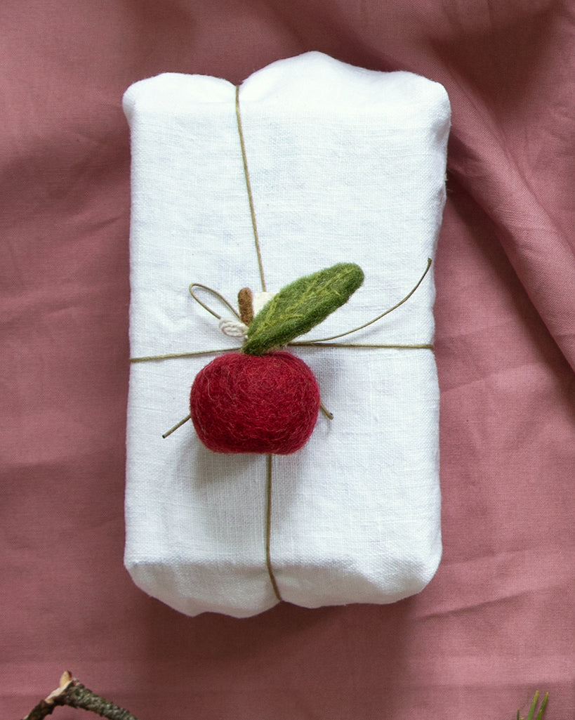 Handgefilzter dunkelroter Apfel von Gry & Sif – hier als süsser Geschenkanhänger