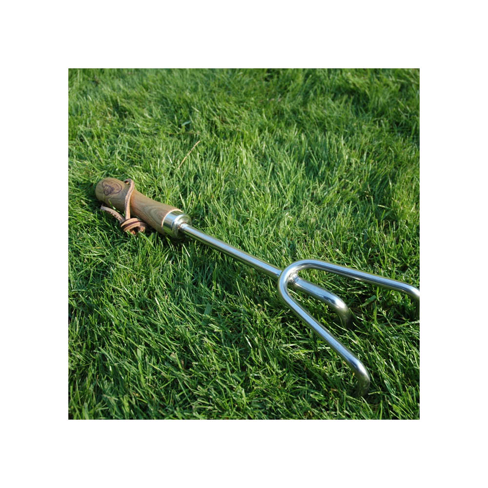 Handharke auf dem Rasen – ideal zum Auflockern und Belüften der Erde