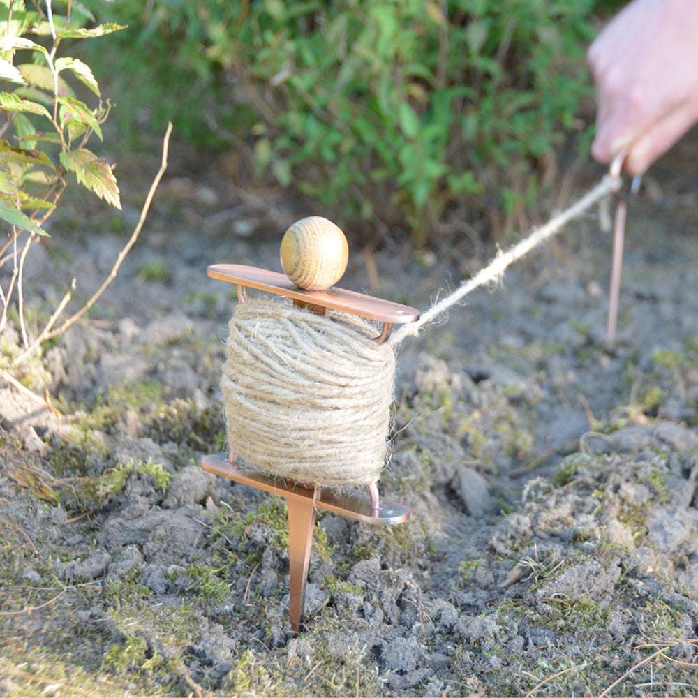 Pflanzleine mit verkupferter Spule und Juteschnur beim Ausrichten von Beetreihen