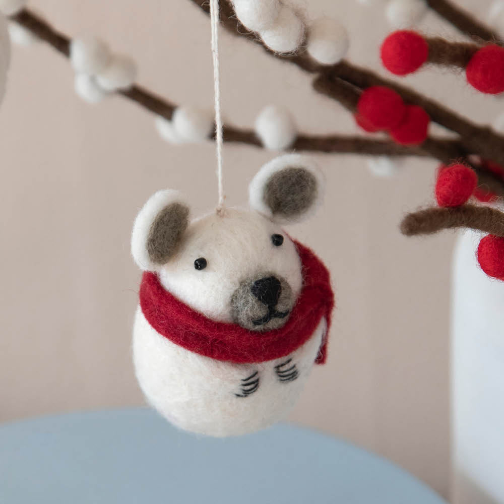 Handgefilzter Filzanhänger Eisbär mit rotem Schal aus Schurwolle von Gry & Sif – winterliche Deko mit nordischem Charme an einem Ast.