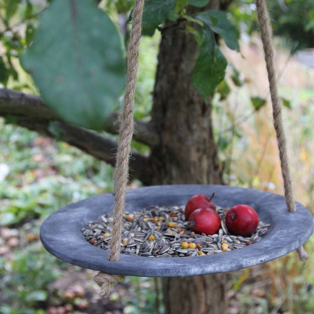 Hängendes Vogelbad von Eldgarden in Steinoptik – mit Vogelfutter und roten Äpfeln