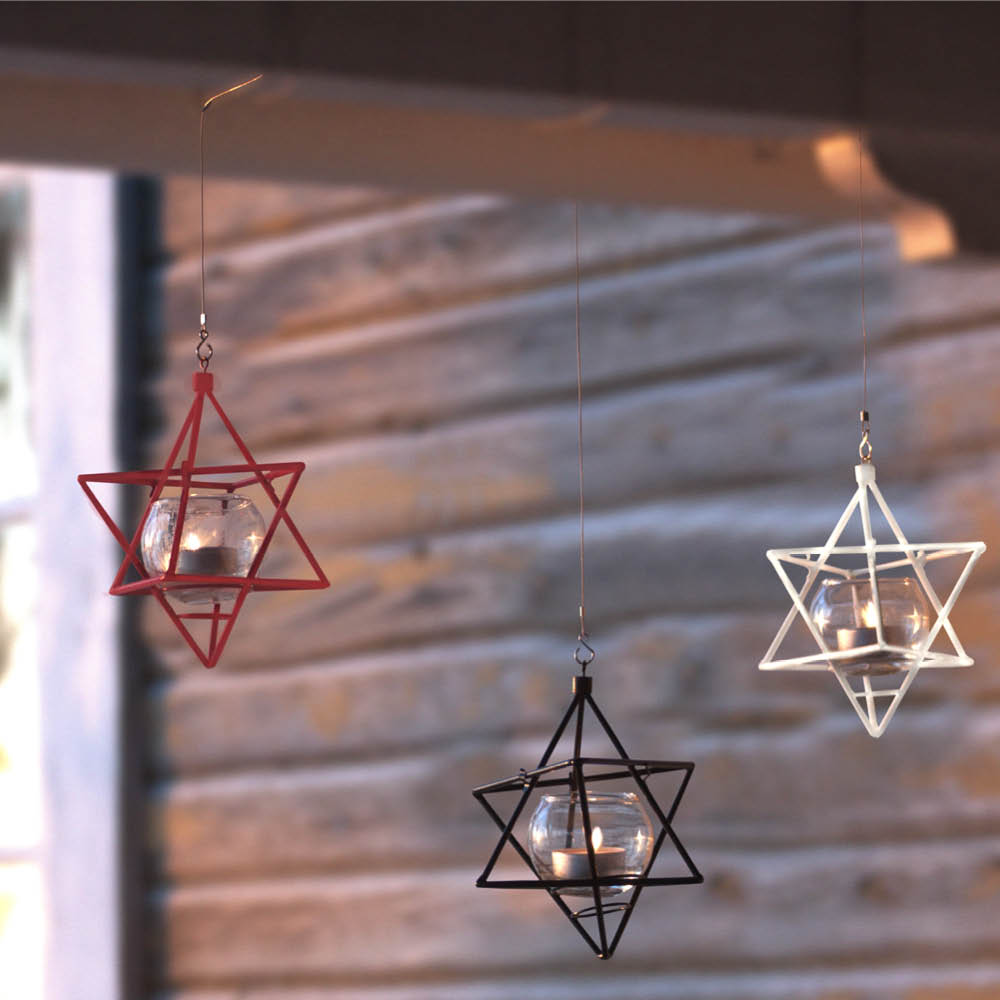 Teelichthalter im Meisenknödelspender Stern aufgehängt vor Holzwand