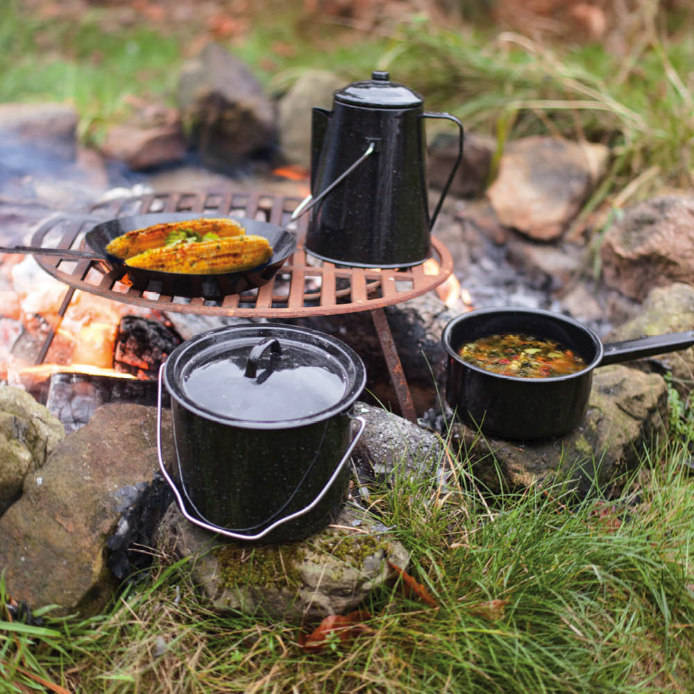 Outdoor Kochset mit Kaffeekanne und Pfanne über Lagerfeuer