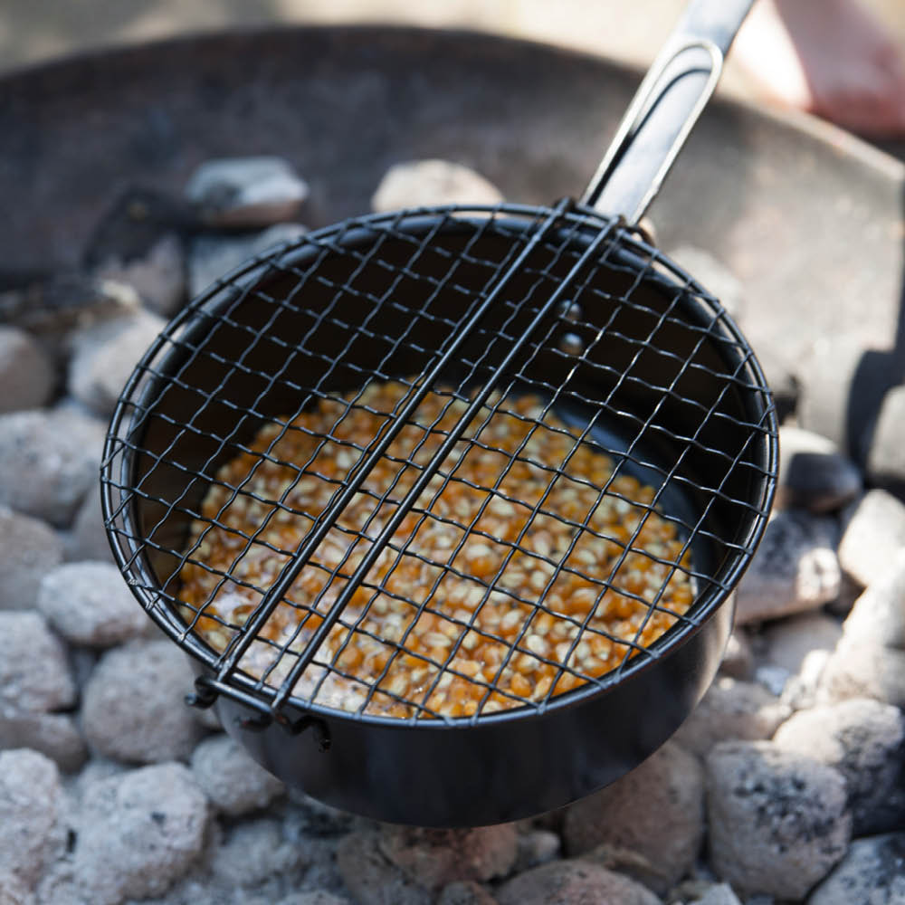Popcornpfanne mit langem Stiel über Feuerschale