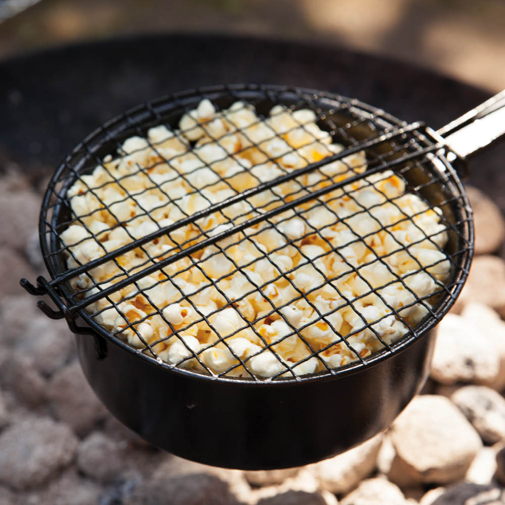 Popcornpfanne über Grill mit frischem Popcorn im Freien
