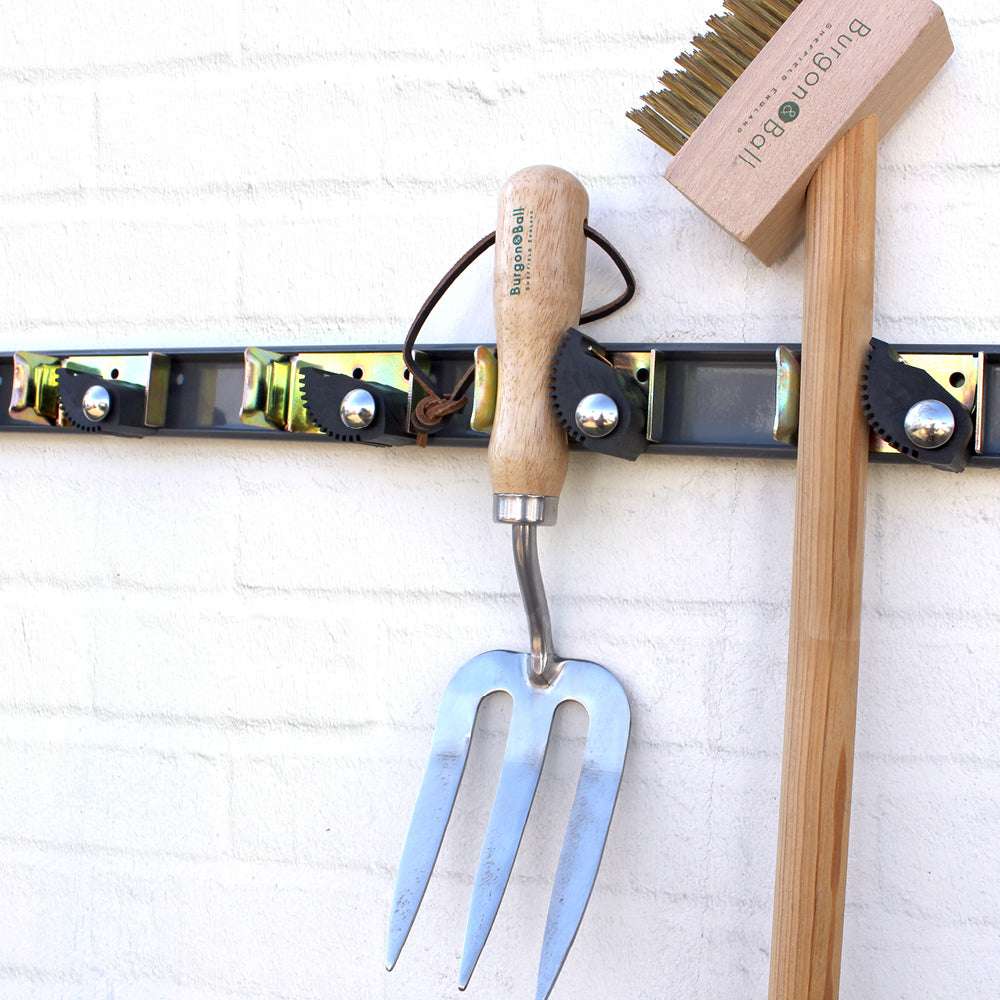 Werkzeug-Halterung an Wand mit aufgehängtem Gartenwerkzeug