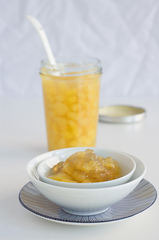 Selbstgemachte Birnenmarmelade mit Vanille in einer weißen Schale auf einem kleinen Teller serviert