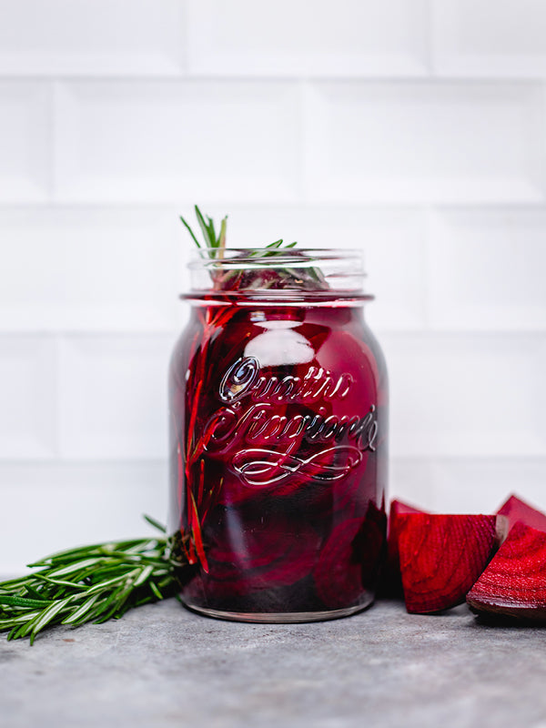 Schnell fermentierte Rote Bete in Scheiben mit Rosmarinzweigen, eingelegt in einem Glas mit Essigsud – leuchtend rot und hausgemacht