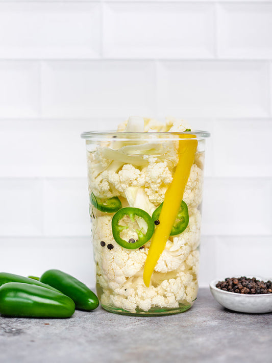 Scharf fermentierter Blumenkohl mit Karotten, Habanero-Chili und Pfefferkörnern in einem Einmachglas – bunt, hausgemacht und würzig