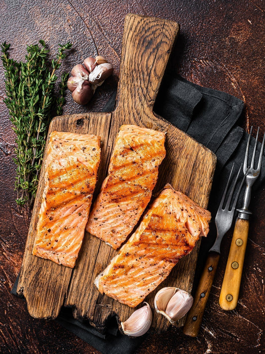 Saftig gegrillte Lachsfilets auf rustikalem Holzbrett