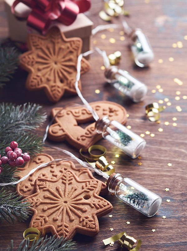 : Hausgemachter Spekulatius – goldbraune Weihnachtskekse in Stern- und Herzform, auf Holztisch mit Tannenzweigen und festlicher Deko angerichtet.