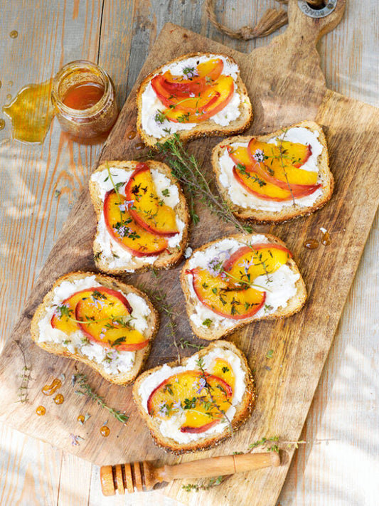 Süße Bruschetta mit Frischkäse, karamellisierten Pfirsichen, Honig und Thymian auf Brot