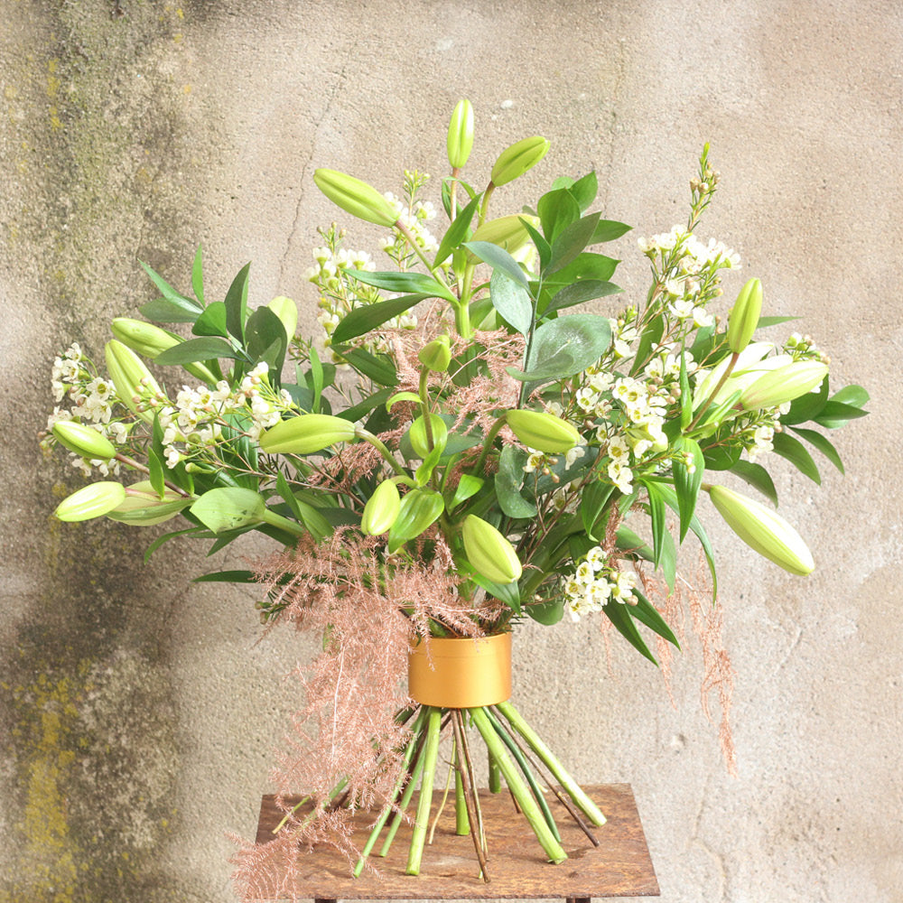 Frischer Blumenstrauß mit Chrysanthemen und Clematis, Lilien und Wachsblumen mit dem Hanataba „Champagne Gold“.