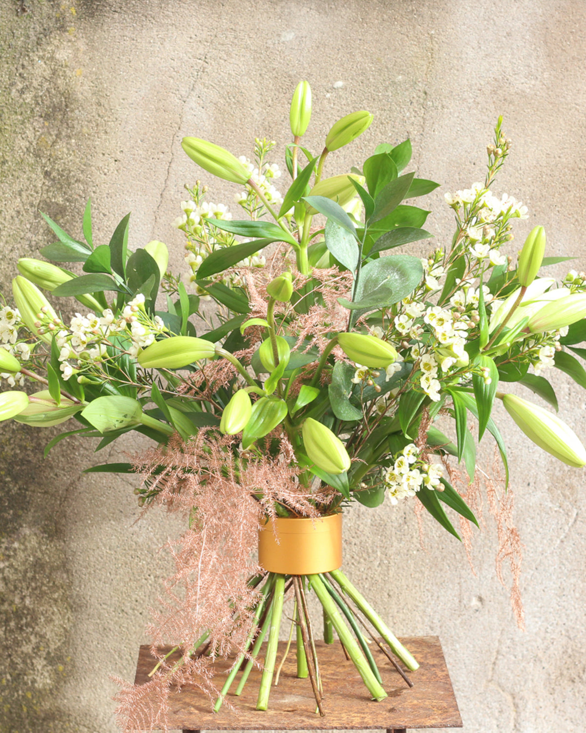 Frischer Blumenstrauß mit Chrysanthemen und Clematis, Lilien und Wachsblumen mit dem Hanataba „Champagne Gold“.