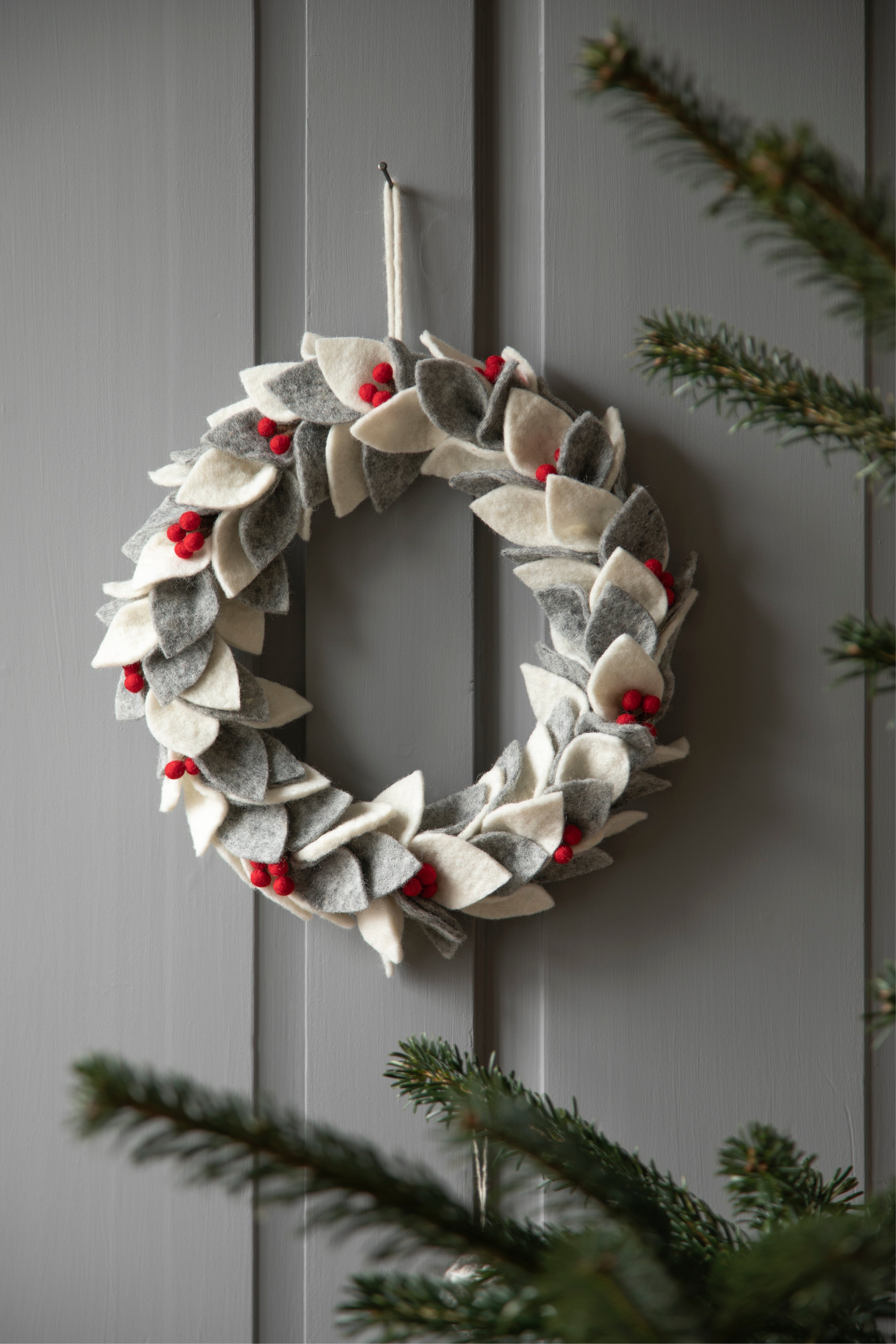 Handgefilzter Weihnachtskranz in Weiß und Grau mit roten Beeren von Gry & Sif – Winterdeko aus Schurwolle