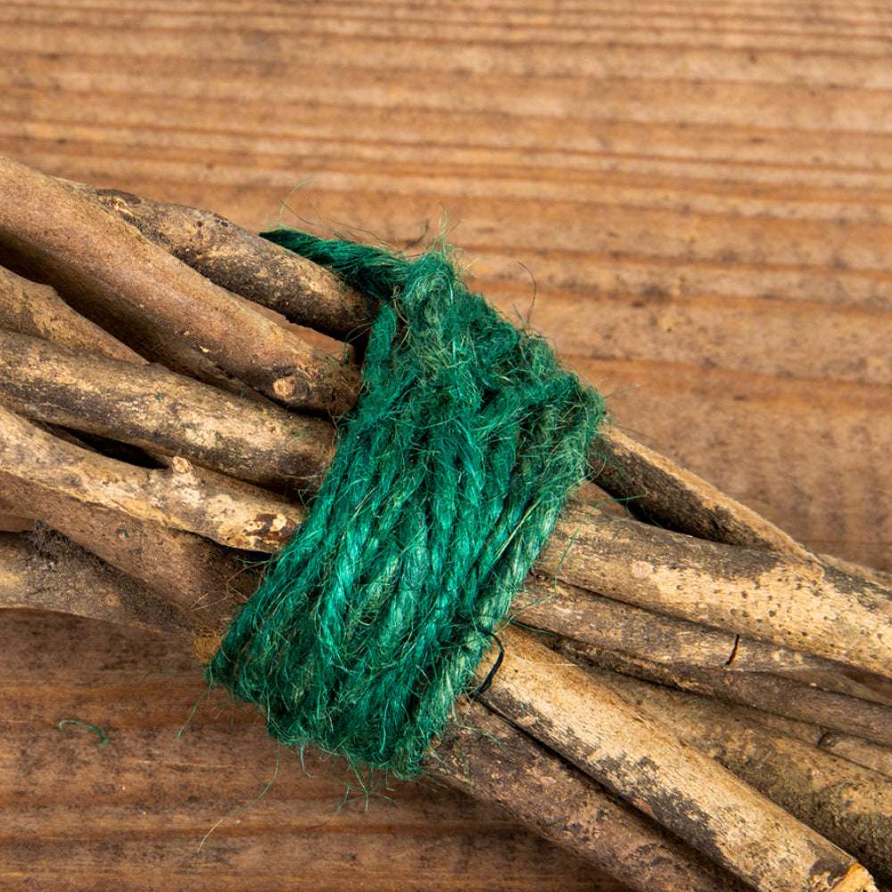 Grüner Jutebindfaden im Einsatz zum Fixieren von Pflanzen im Garten