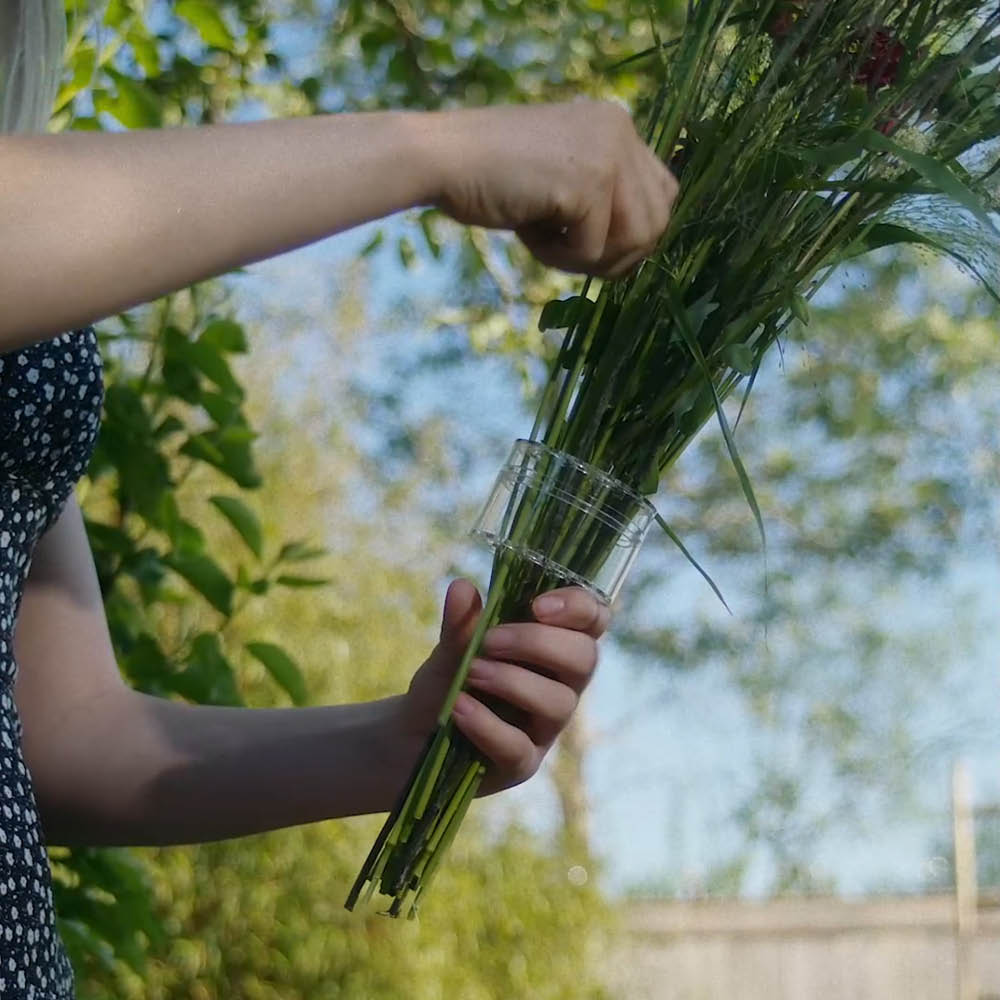 Hand arrangiert Blumenstiele mit dem Hanataba „Crystal Clear“ im Garten.