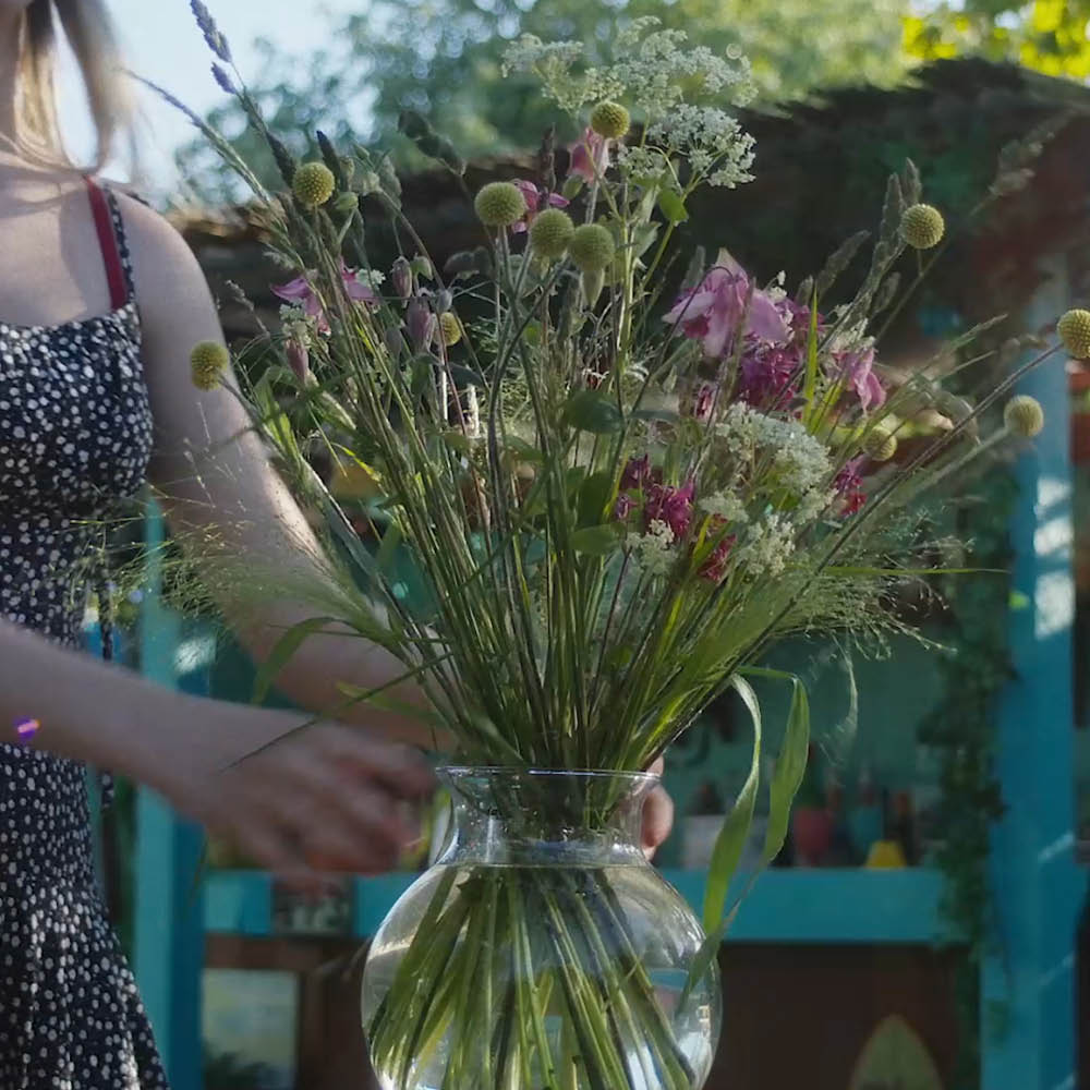 Blumenstiele werden mit dem Hanataba „Crystal Clear“ in einer Vase arrangiert.