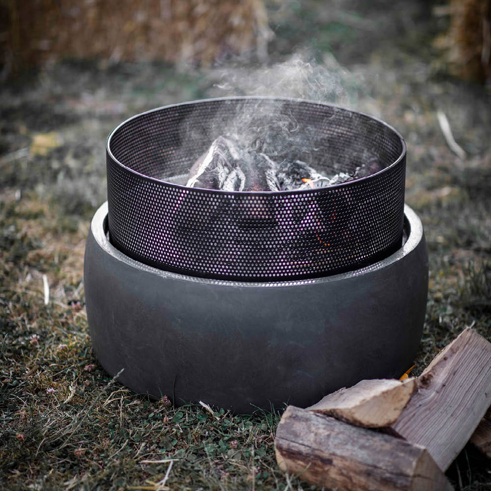Feuerstelle Lyneham mit brennendem Holz im Garten bei Abendstimmung
