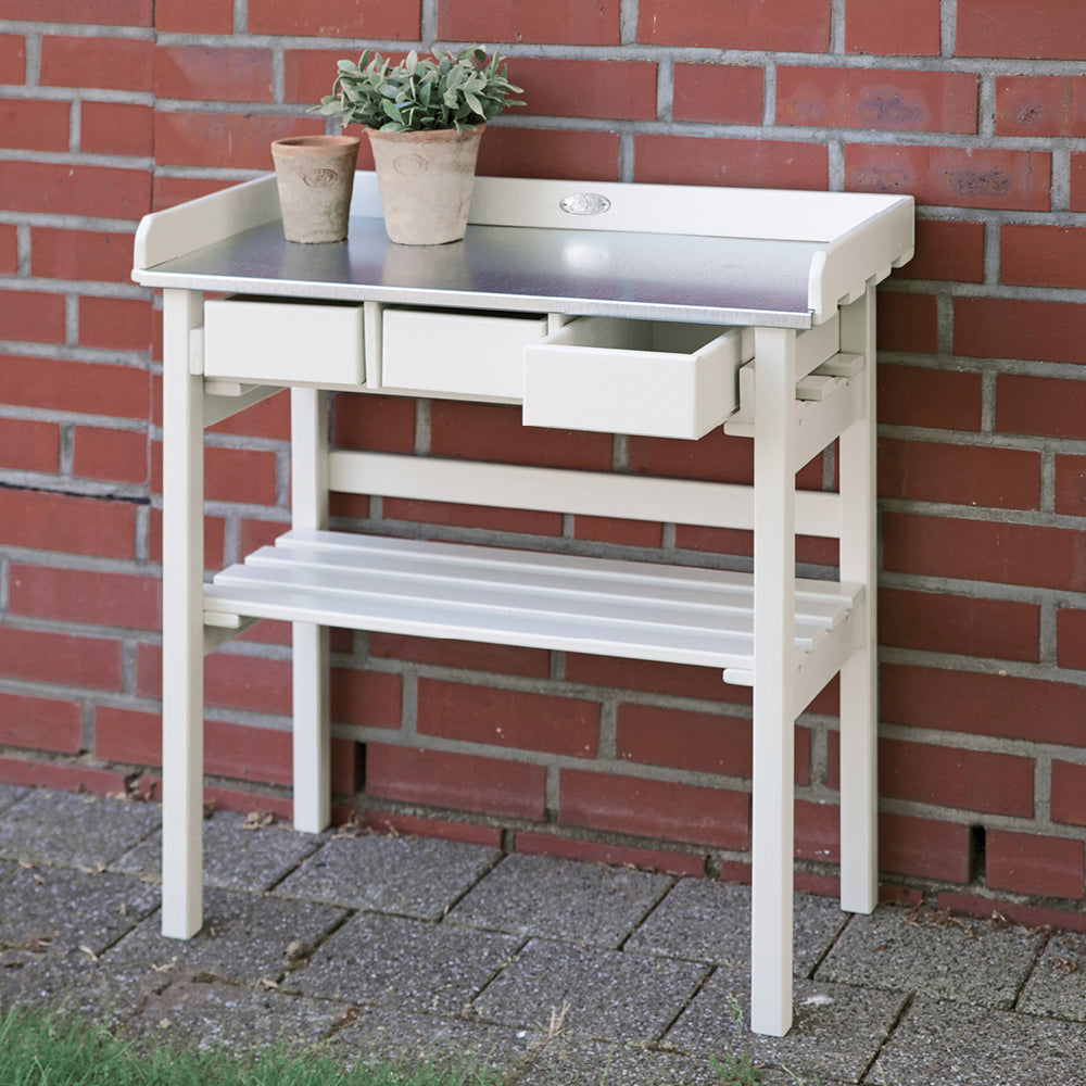 Stilvoller Gartenarbeitstisch aus Holz für Balkon oder Terrasse vor einer Hausand