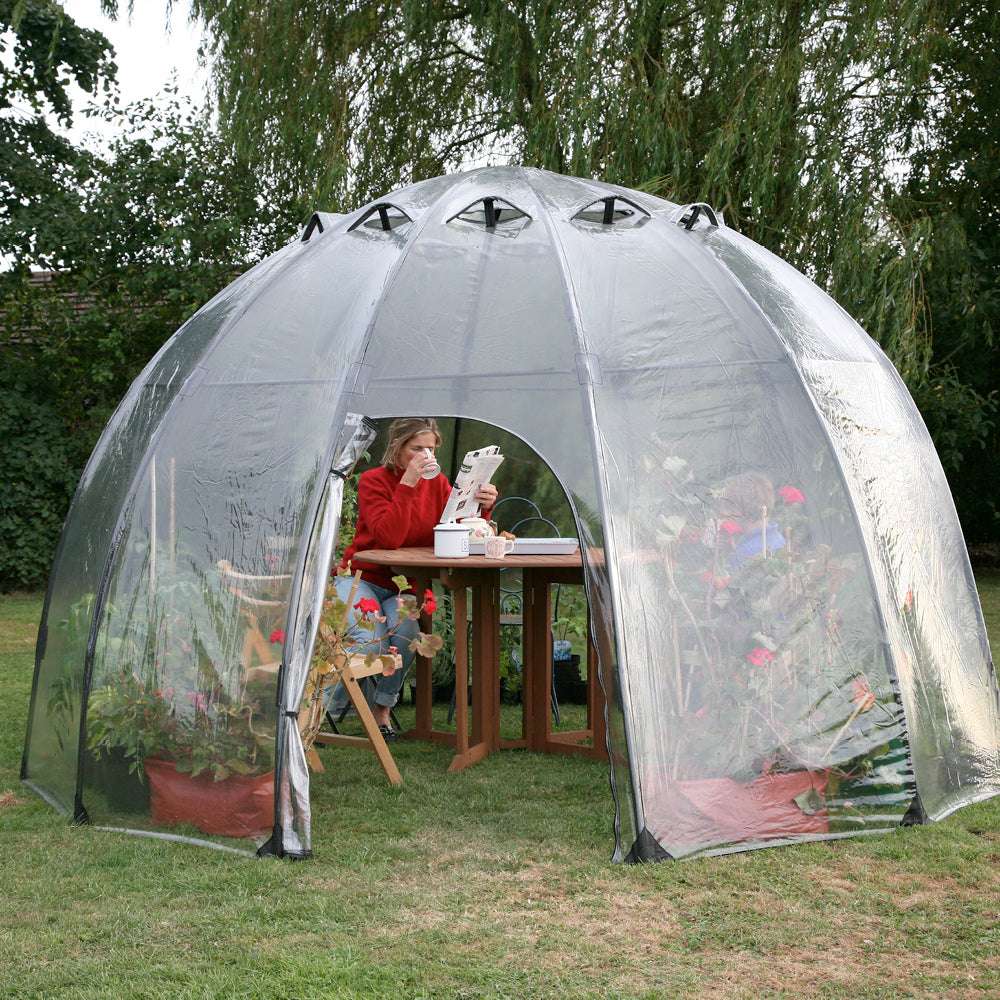 Eine Frau sitzt im Haxnicks Sunbubble Gewächshaus 