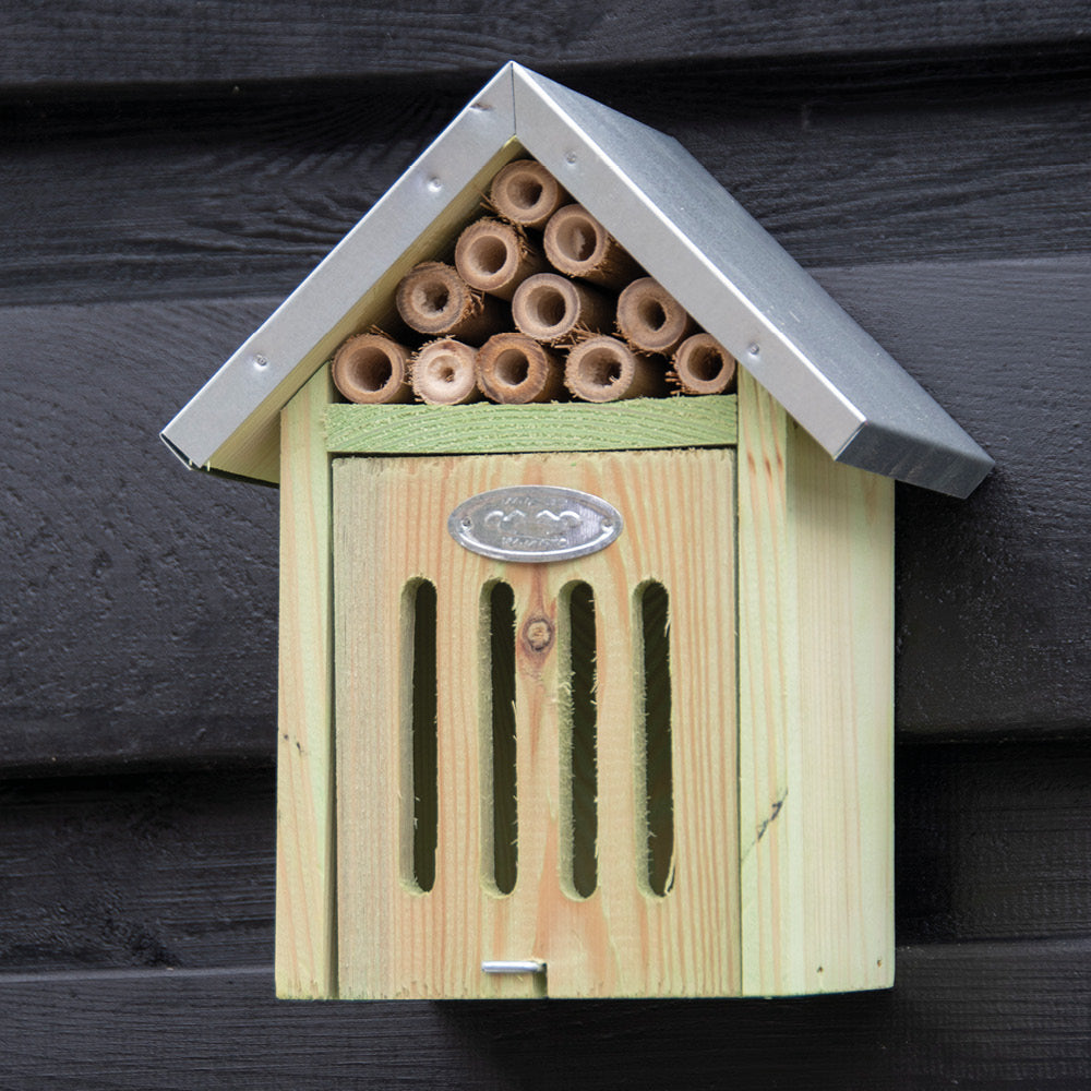 Insektenhotel aus Holz mit Bambusröhrchen für Wildbienen an der Hauswand